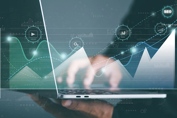 Person typing on laptop with charts coming out of it.