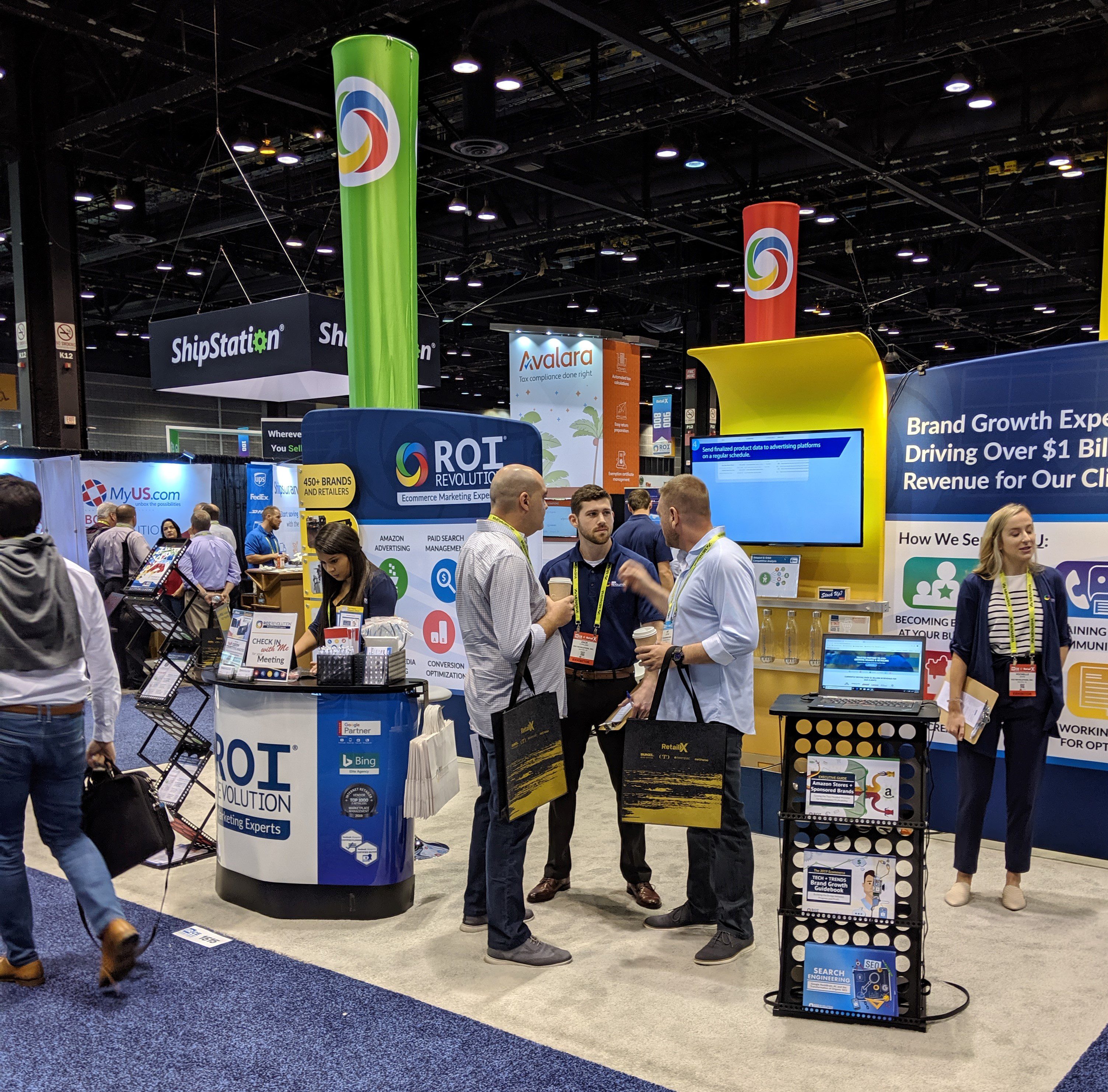 Photo of people talking at ROI Revolution's booth at IRCE 2019 Day 1
