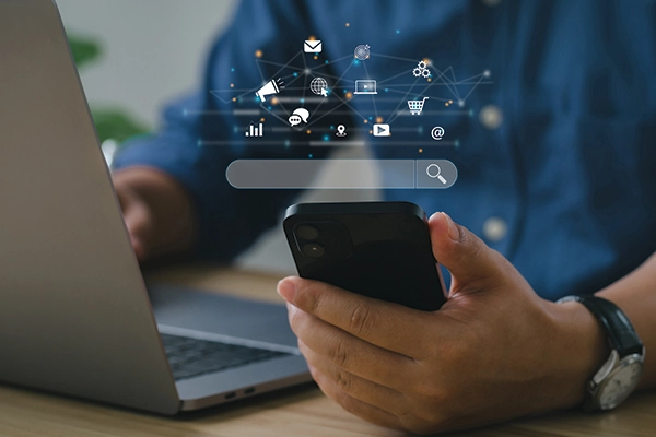 Man holding phone with search bar and icons on top of it.