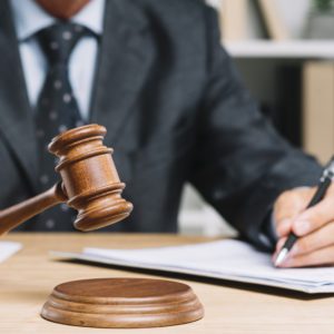 Photo of a man in a suit holding a gavel.