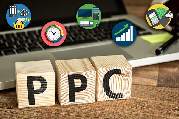 Three wooden blocks near a laptop that say "PPC".