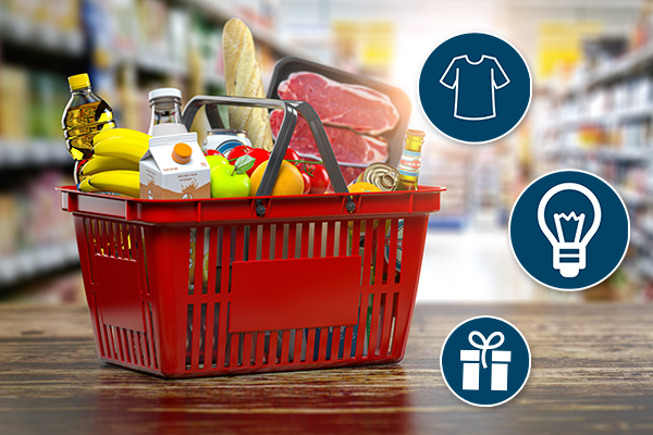 Miniature shopping cart on floor of grocery store packed with items such as milk, apples, oranges, bananas, bread, steak, olive oil, etc.