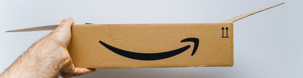 Man holding against white background freshly unboxed Amazon Prime cardboard box