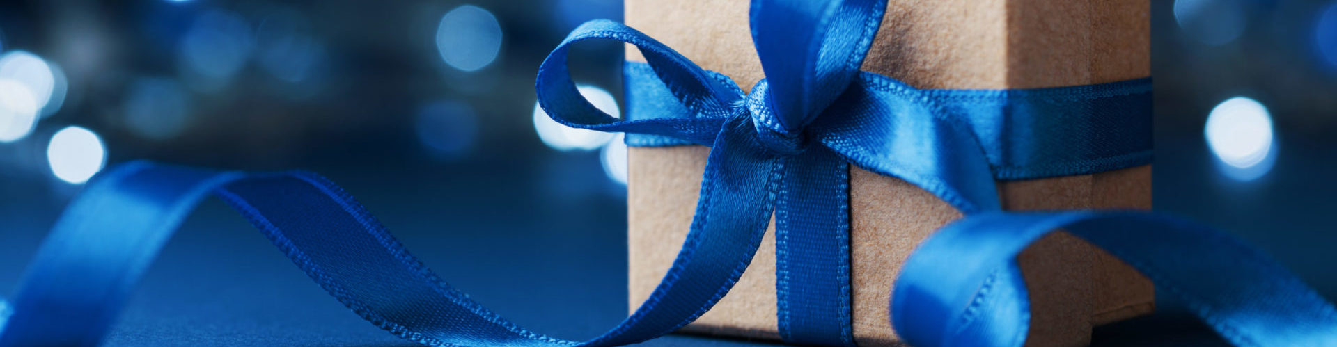 2022 holiday ecommerce strategy - gift box with blue ribbon and blue background