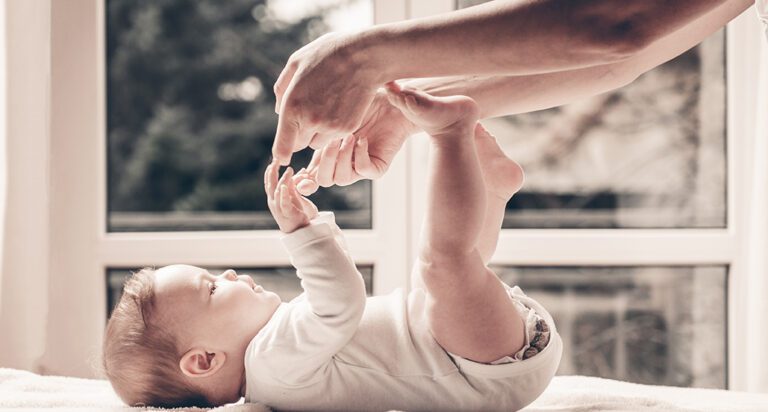 Small baby playing with adult.