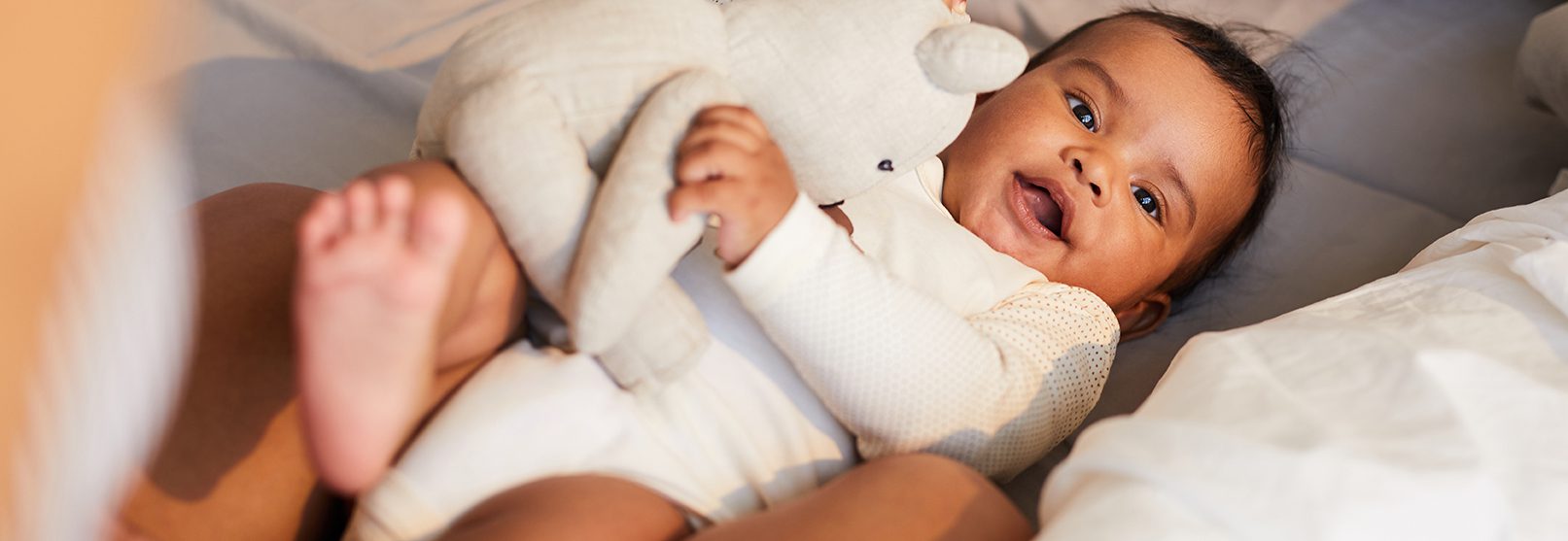 Small baby holding stuffed elephant.