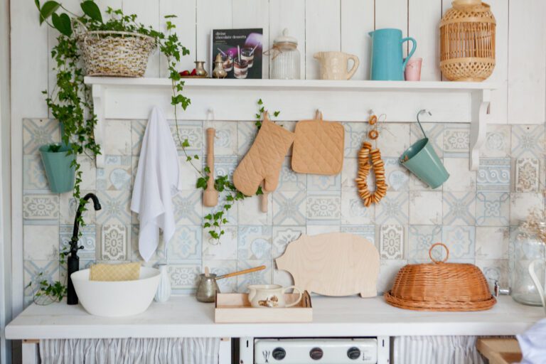 Kitchen towel and glove on work top in modern kitchen, kitchen accessories hanging in the roof rail on the white wall.
