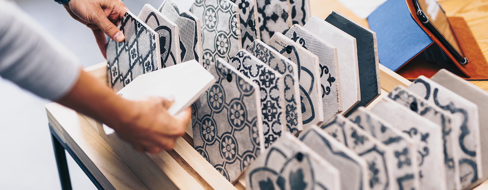 Person rummaging through collection of blue and white tiles.