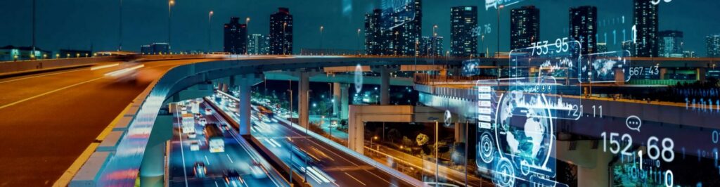 Blurred scene of cars racing on a highway in front of a city landscape at night.