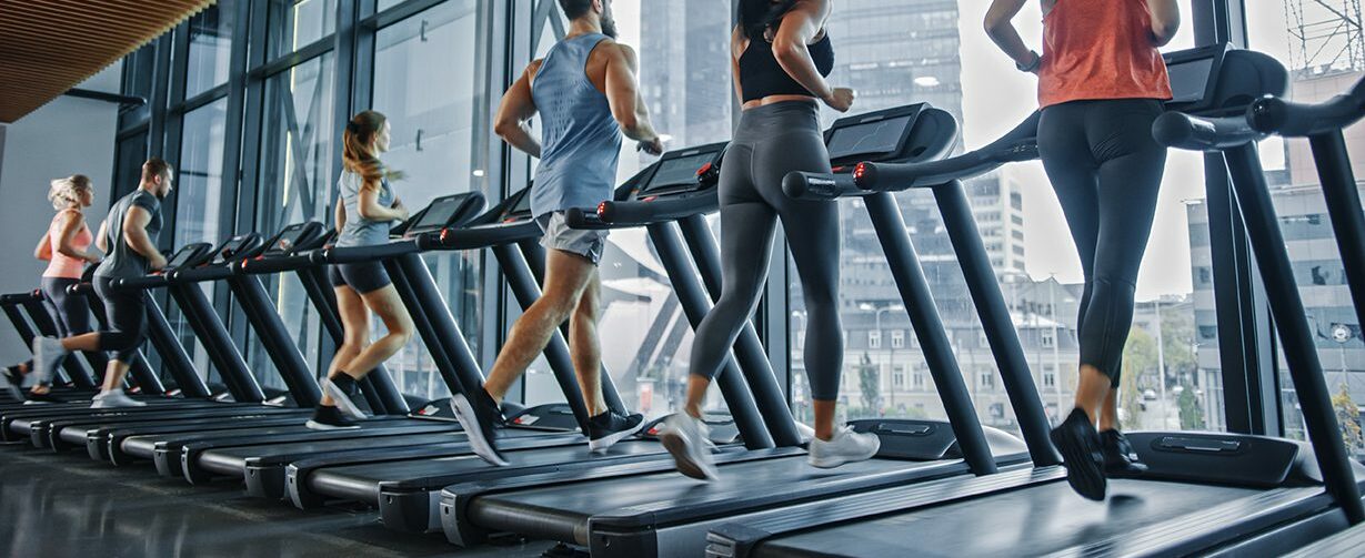 People lined up on treadmills running.