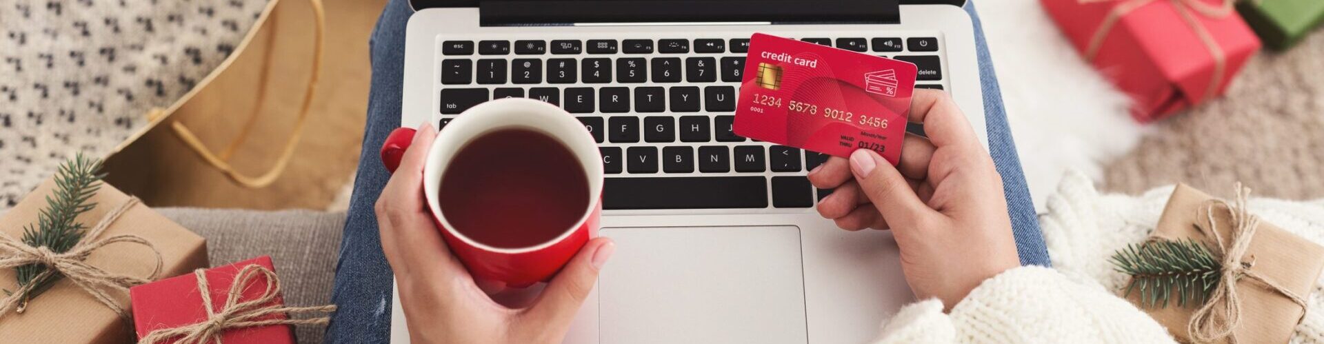 Christmas shopping. Woman ordering presents on laptop and drinking coffee, copy space