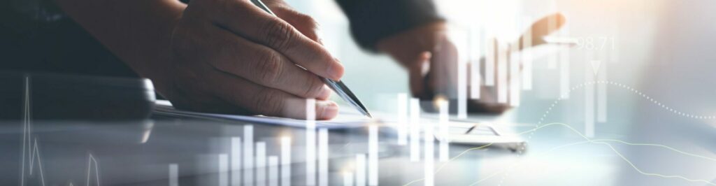 Hand holding a pen with an overlay of graph bars.