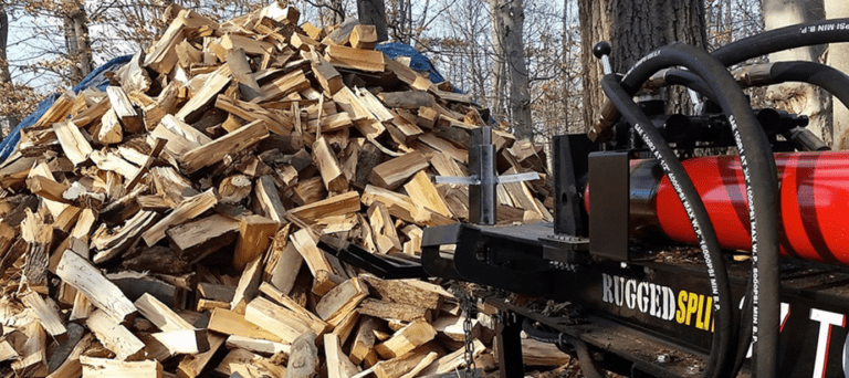 RuggedMade 37 ton RuggedSplit log splitter in front of tall pile of split wood.