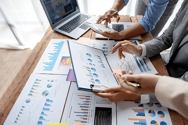 Business people looking at printed out charts.