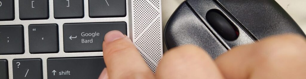 A person pressing a keyboard key with the word Google Bard an Artificial Intelligence (AI) chatbot robot app developed by Google