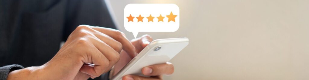 Woman holding a cell phone leaving a five-star review.