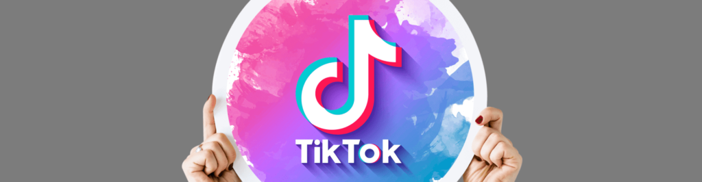 Woman holding sign with TikTok logo on it.