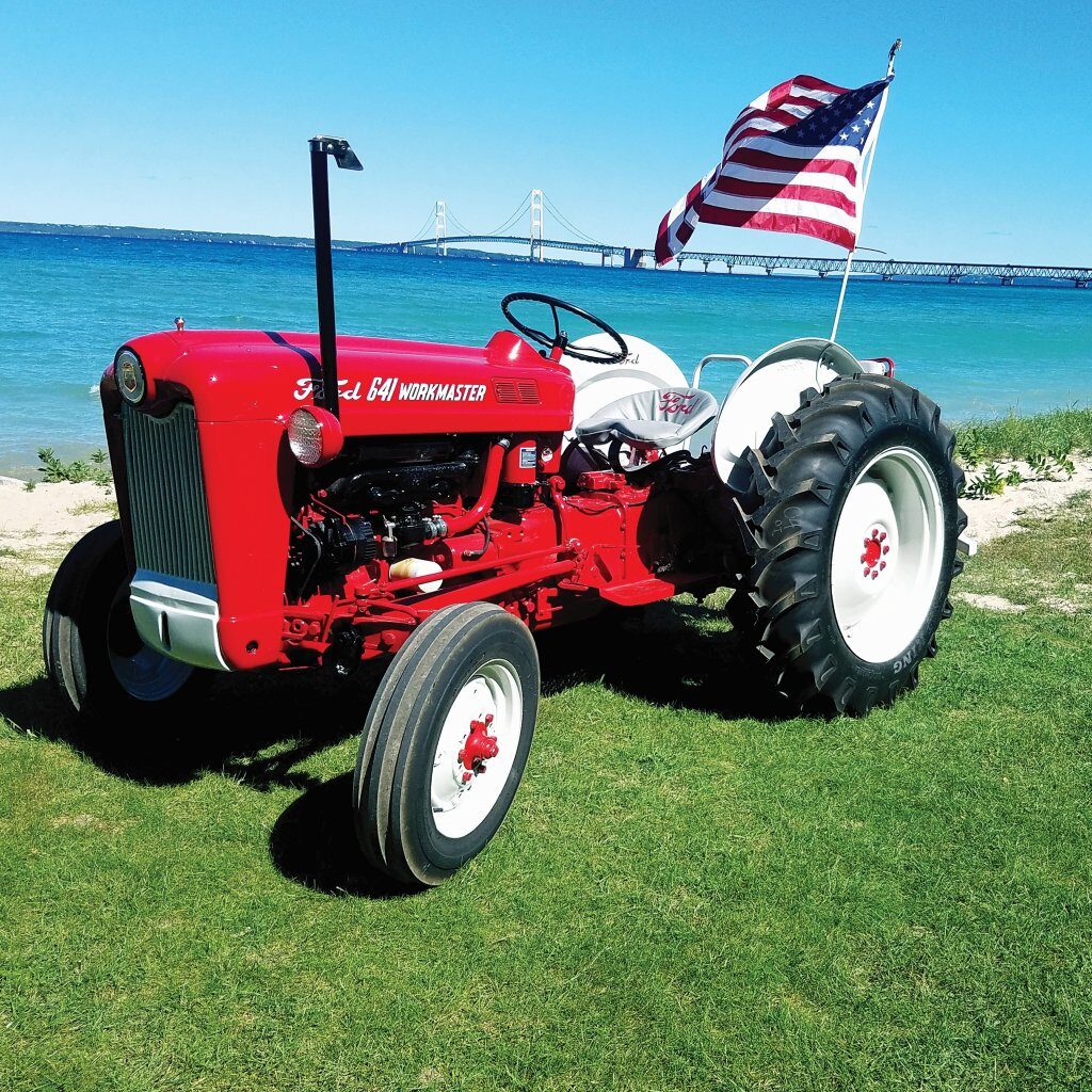 Antique Ford tractor on grass near water