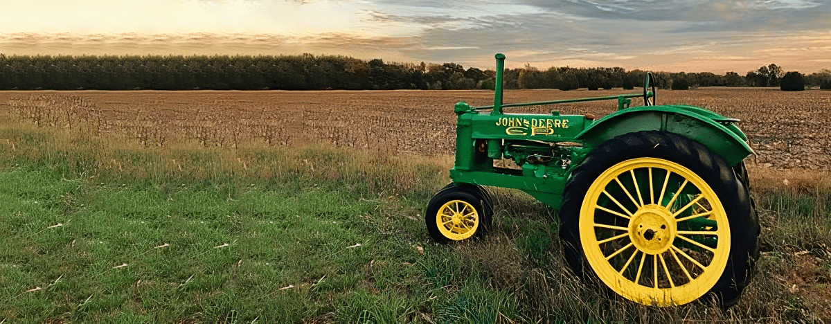 john deere truck in a farming field during sunset