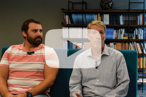 Joe Del Vecchio and David Austin speaking about media mix modeling with a video play button on top.