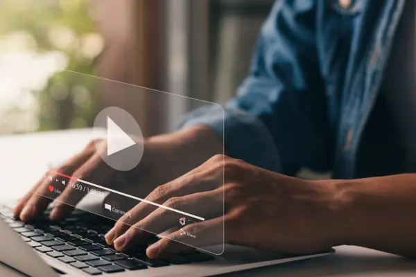 Man typing on keyboard with video box and play button popping up.