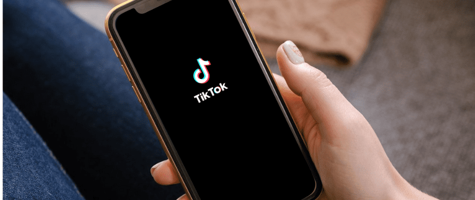 hand holding iphone with TikTok screen loading