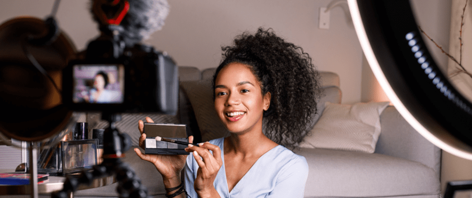 content creator shooting user generated content holding up makeup product