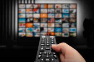 hand holding remote selecting connected tv channel to stream