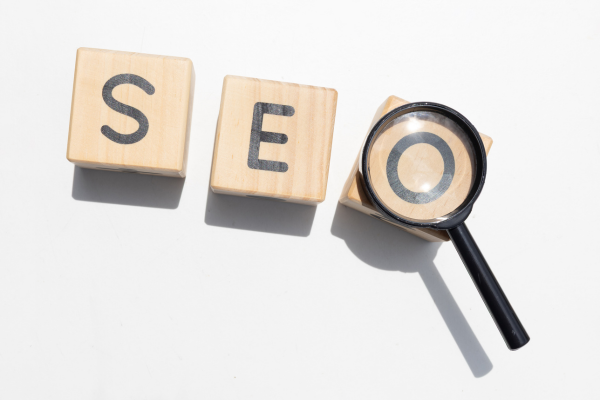 Photos of blocks spelling SEO with magnifying glass over letter O