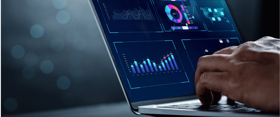 Close up of hands typing on laptop. Screen displays illuminated performance data